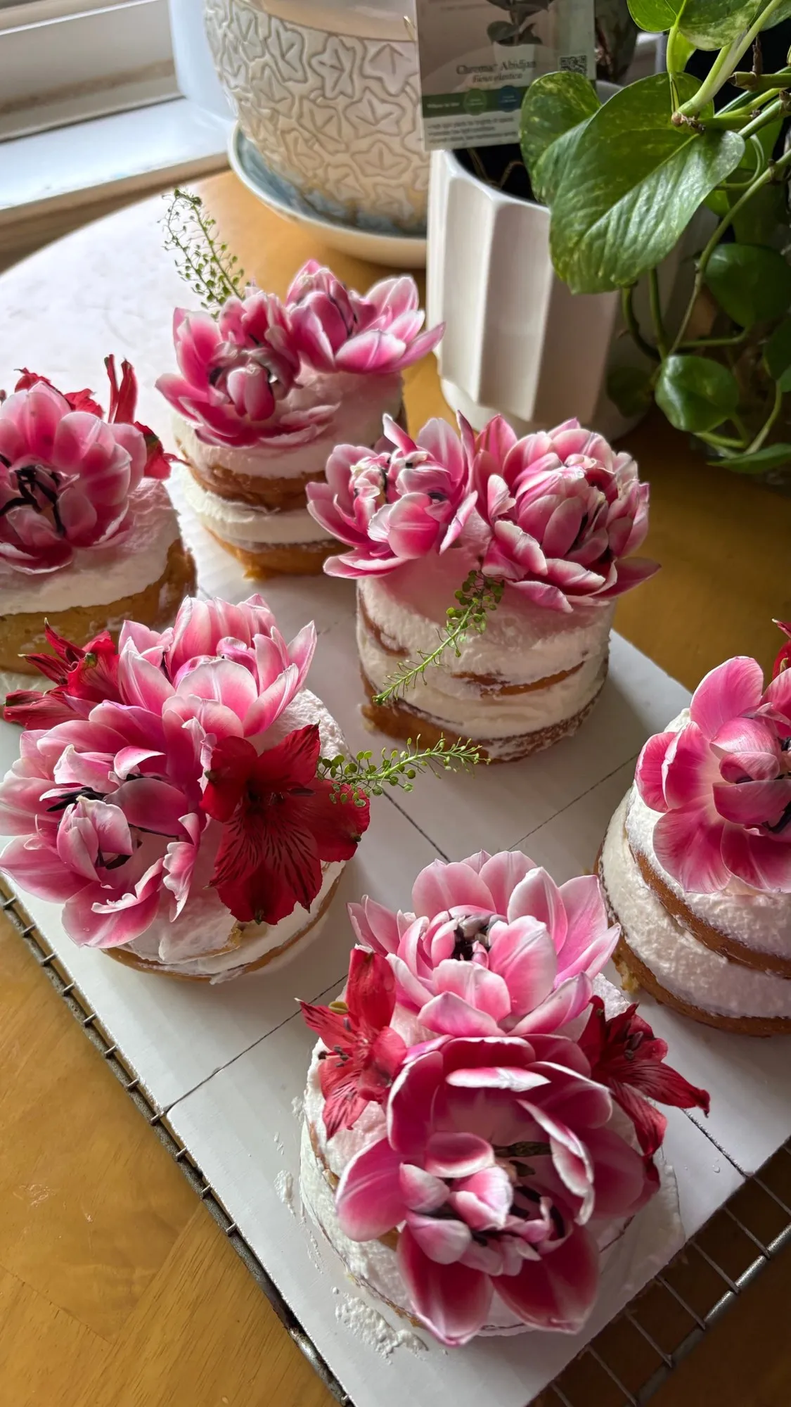 Naked-style mini cakes topped with fresh pink tulips and lilies