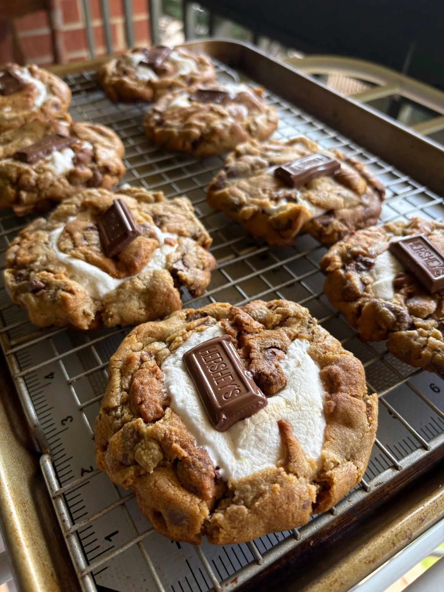 Close view of gooey s'mores cookies with marshmallow and chocolate on a baking rack